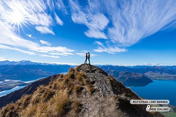 Couple holding hands kissing at Roys Peak, Lake Wanaka, New Zealand 